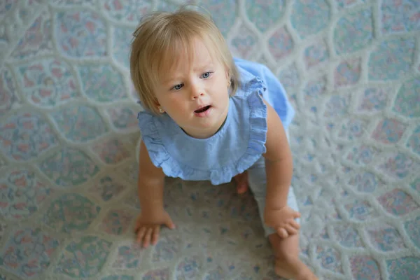 Kindheit, Babyalter und Menschen-Konzept. glückliches kleines Mädchen, das zu Hause auf dem Boden sitzt. Blick von oben — Stockfoto