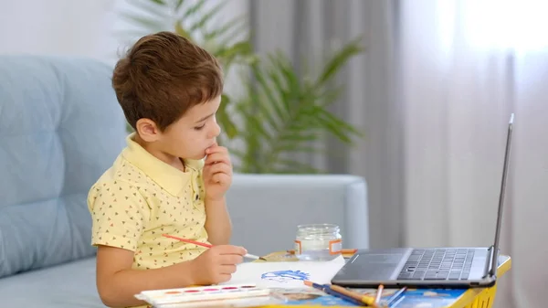 Μικρό χαριτωμένο αγόρι ζωγραφίζει με μολύβια. το παιδί ασχολείται με τη δημιουργικότητα στο σπίτι — Φωτογραφία Αρχείου