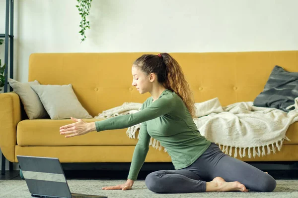 Schöne junge Frau beim Yoga zu Hause. Fitnesstraining online. — Stockfoto