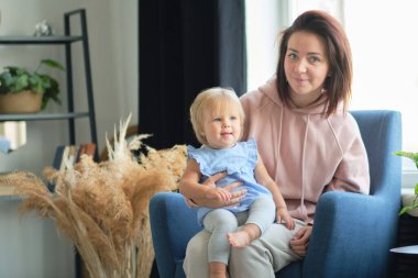 Anne ve küçük çocuk oturma odasındaki stüdyoda oturuyorlar ve birlikte oynuyorlar. Mutlu annelik. Aşk eğitimi.