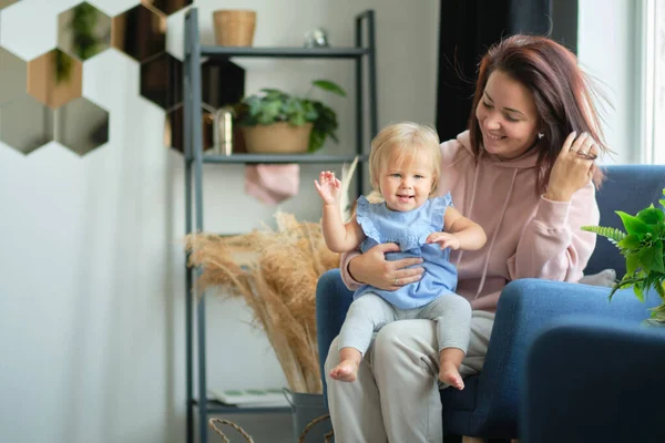 Mamma och barn sitter i studion i vardagsrummet och leker tillsammans. Lycklig mor. utbildning genom kärlek. — Stockfoto