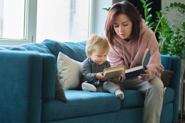 Annem kanepede kitap okuyor. Uyumadan önce. Çocuklarla ilgilenmek. Anneler kızlarını sever.