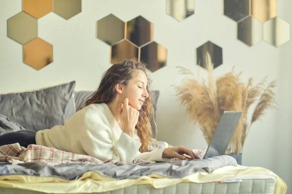 Uśmiechnięta kobieta pisząca na laptopie w pokoju hotelowym. — Zdjęcie stockowe