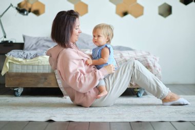 Anne ve küçük çocuk oturma odasındaki stüdyoda oturuyorlar ve birlikte oynuyorlar. Mutlu annelik. Aşk eğitimi.