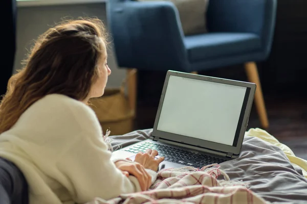 Boldog alkalmi gyönyörű nő dolgozik egy laptop ül az ágyon a házban. — Stock Fotó