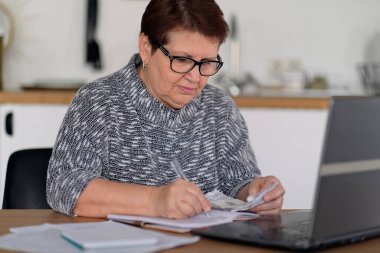 Yaşlılar, vergi beyannamesi ve ev bankacılığı. Federal vergi ödeyen, aile bütçesiyle uğraşan yaşlı bir bayan. Yaşlı İspanyol bir insan ve stres. Para kavramı, finans, mali sorunlar