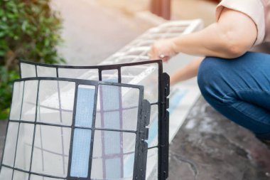 Hizmetçi, havalandırma sistemini temizliyor, yerdeki kirli klimaları yıkıyor. Seçici odaklanma. Bakım ve servis kavramları