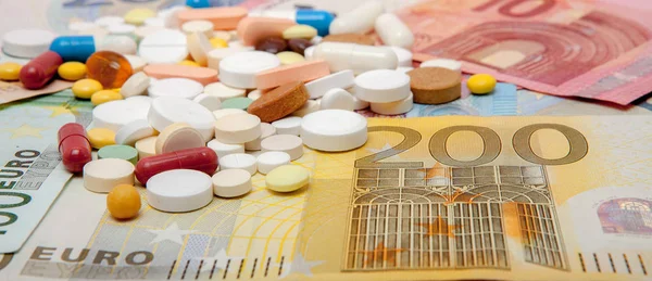 Money and pills. Pills of different colors on money. medicine concept. Euro cash.