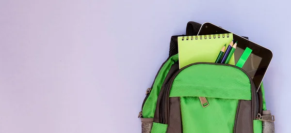 Rucksack mit Schulsachen auf violettem Rücken — Stockfoto