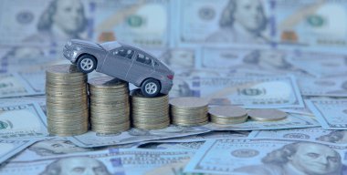 Paraları dolar arka plan üzerinde bir çubuk grafik şeklinde olan bir araba gri modeli. Borç verme, tasarruf, sigorta kavramı.