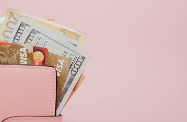 Banka kartları, dolar ve euro pembe arka plan kopya alanı ile pembe bir cüzdan.
