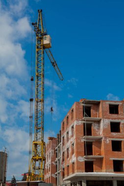 Şantiye binasının bir yeni daire yüksek kule ile mavi gökyüzü karşı vinç. Yerleşim alanı geliştirme. Gayrimenkul Proje büyüme kavramı.