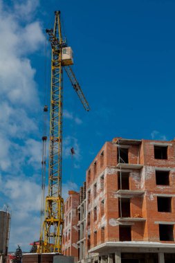 Şantiye binasının bir yeni daire yüksek kule ile mavi gökyüzü karşı vinç. Yerleşim alanı geliştirme. Gayrimenkul Proje büyüme kavramı.
