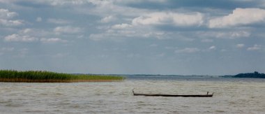 Bir gölde - bir tekne içinde oturan ve teknede ayakta su adlı üç martılar.