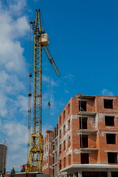Şantiye binasının bir yeni daire yüksek kule ile mavi gökyüzü karşı vinç. Yerleşim alanı geliştirme. Gayrimenkul Proje büyüme kavramı.