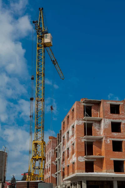 Şantiye binasının bir yeni daire yüksek kule ile mavi gökyüzü karşı vinç. Yerleşim alanı geliştirme. Gayrimenkul Proje büyüme kavramı.
