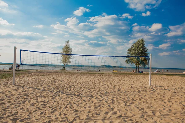 Güneşli bir günde plaj voleybolu ağı. Kumsal ve denizle dolu..