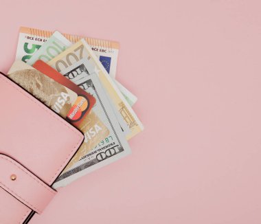 15 Haziran 2018: banka şubesi. Maaş için bir kredi kartı seçme. Banka kartları, dolar ve euro pembe arka plan kopya alanı ile pembe bir cüzdan.
