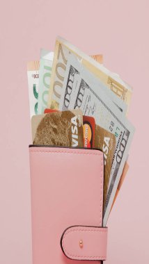 15 Haziran 2018: banka şubesi. Maaş için bir kredi kartı seçme. Banka kartları, dolar ve euro pembe arka plan kopya alanı ile pembe bir cüzdan.