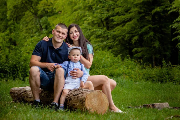 Mutlu anne, baba ve oğul parkta bir kitap okumak.