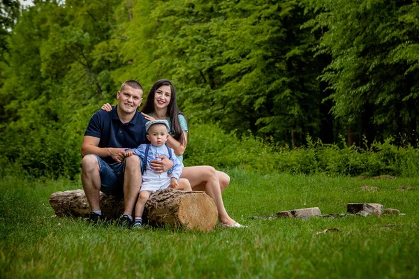 Mutlu anne, baba ve oğul parkta bir kitap okumak.