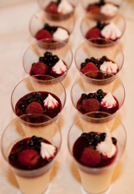 Tatlı çilek ahududu ile bir bardak ve böğürtlenli krema ve granola ile.