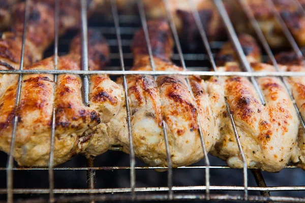 Marinated chicken legs on the grill in the smoke. A picnic, tasty food. BBQ.