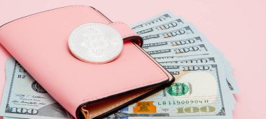 Bitcoin, dolar ve pembe cüzdan pembe arka plan üzerinde.
