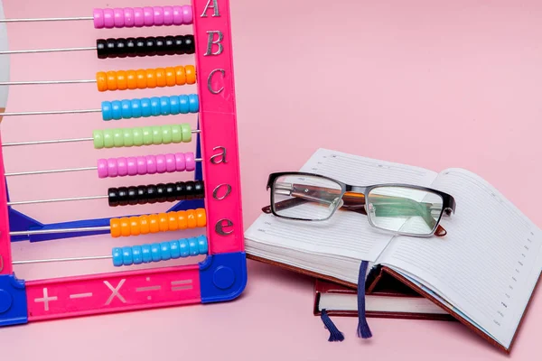 Farbige Abakus Brille Und Notizbuch Auf Rosa Hintergrund Bildung Zurück — Stockfoto