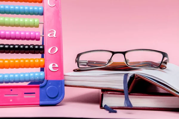 Renkli Abacus Gözlük Pembe Bir Arka Plan Üstünde Defter Eğitim — Stok fotoğraf