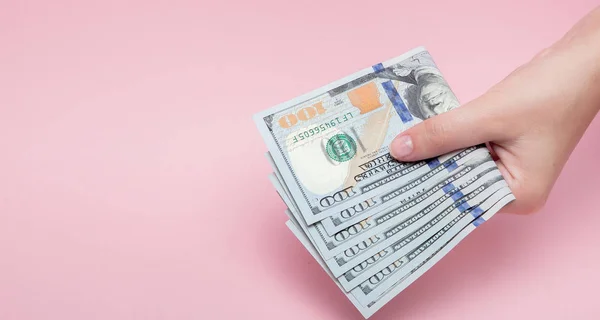 Stapel Dollar Bankbiljetten Vrouwelijke Hand Roze Achtergrond Met Kopie Ruimte — Stockfoto