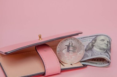 Pembe arka planda fotokopi alanı olan pembe bir cüzdanda Bitcoin ve dolar