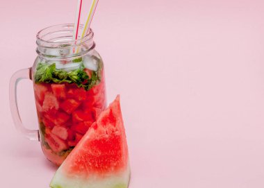 Tazelik karpuz meyve dilim ve yaprak üzerinde pembe bir arka plan, kopya alanı, nane kokteyli yakın çekim