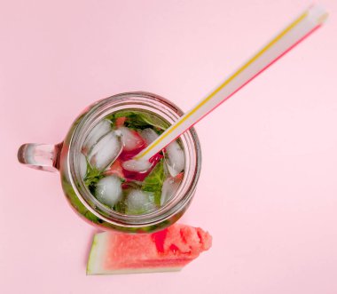 Tazelik karpuz meyve dilim ve yaprak pembe arka plan üzerine nane kokteyli