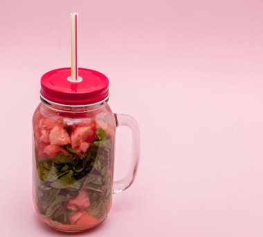 Kavanoz parça çubuk, pembe arka plan içme ve karpuz ile soğuk taze limonata