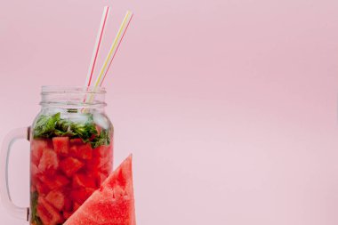 Karpuz smoothie meyve dilim ve pembe bir arka plan, kopya alanı, üzerine nane yaprağı ile yakın çekim