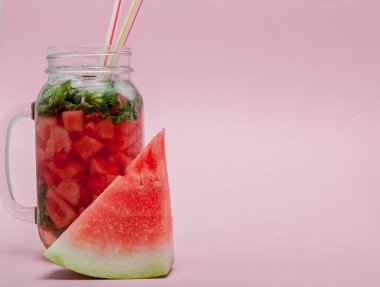 Karpuz smoothie meyve dilim ve pembe bir arka plan, kopya alanı, üzerine nane yaprağı ile yakın çekim