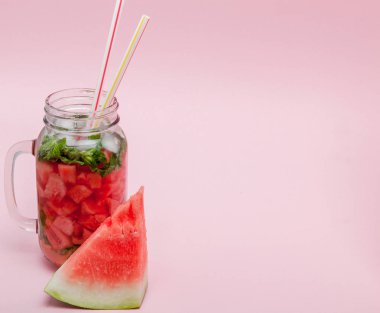 Karpuz smoothie meyve dilim ve pembe bir arka plan, kopya alanı, üzerine nane yaprağı ile yakın çekim.