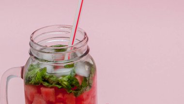 Tazelik karpuz meyve dilim ve yaprak üzerinde pembe bir arka plan, kopya alanı, nane kokteyli yakın çekim.