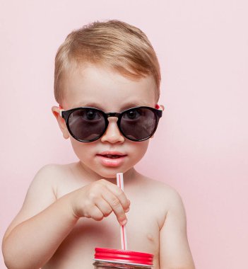Kavanoz dilim karpuz ve pembe bir arka plan üzerinde buz ile soğuk taze limonata ile küçük çocuk.