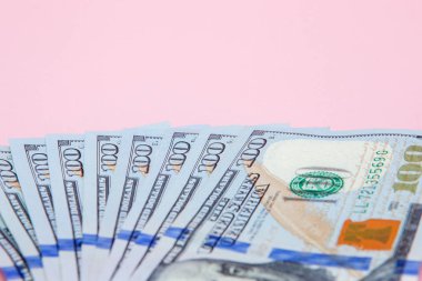 Pembe bir arka plan üzerinde yüz dolarlık banknot. Düz yatıyordu, en iyi görünüm, kopya alanı.