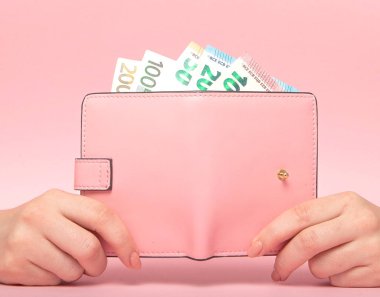 Pembe çanta ve Euro banknot erkek pembe arka plan eller. İş kavramı.