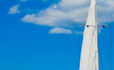 White Yat mavi bulutlu gökyüzü arka plan üzerinde güneş ışığında yola çıkacak. Aşağıdan görüntüleyin. Açık havada yaz canlı renkli yatay görüntü