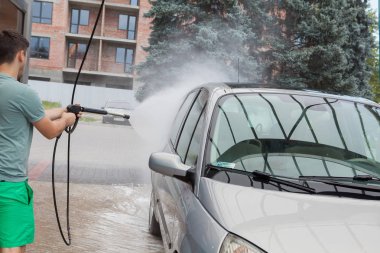Beyaz adam için modern bir araba temizlik su araba yıkama yüksek püskürtme. Modern araç ve açık havada yıkama. Araba yıkama kavramı.