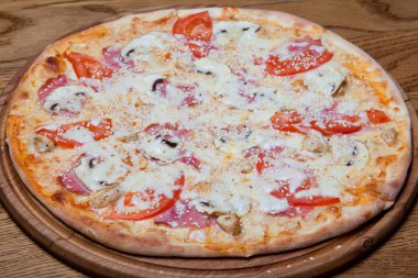 Pizza Milano kremsi Bankası, tavuk fileto, mantar, domates, mozzarella peyniri, sos kekik bir plaka üzerinde