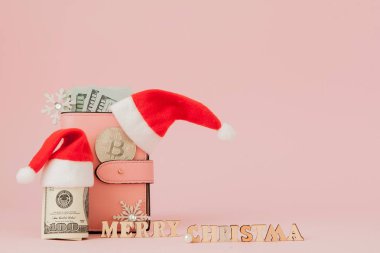 Noel giderleri. Noel Baba şapkası, Hediyelik, köknar ağacı ve dolar Lirası üstünde pembe bir arka plan ile pembe deri çanta. Noel alışveriş. Tatil satış