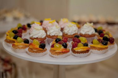 ahududu, üzüm ve şeftali bir düğün tablo ile cupcakes.