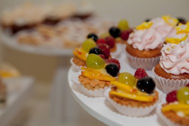 ahududu, üzüm ve şeftali bir düğün tablo ile cupcakes.