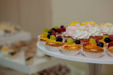 ahududu, üzüm ve şeftali bir düğün tablo ile cupcakes.