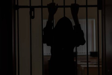 Esir parmaklıklar arkasında. Çaresizlik içinde ızgaralar üzerinde elinizle tutun